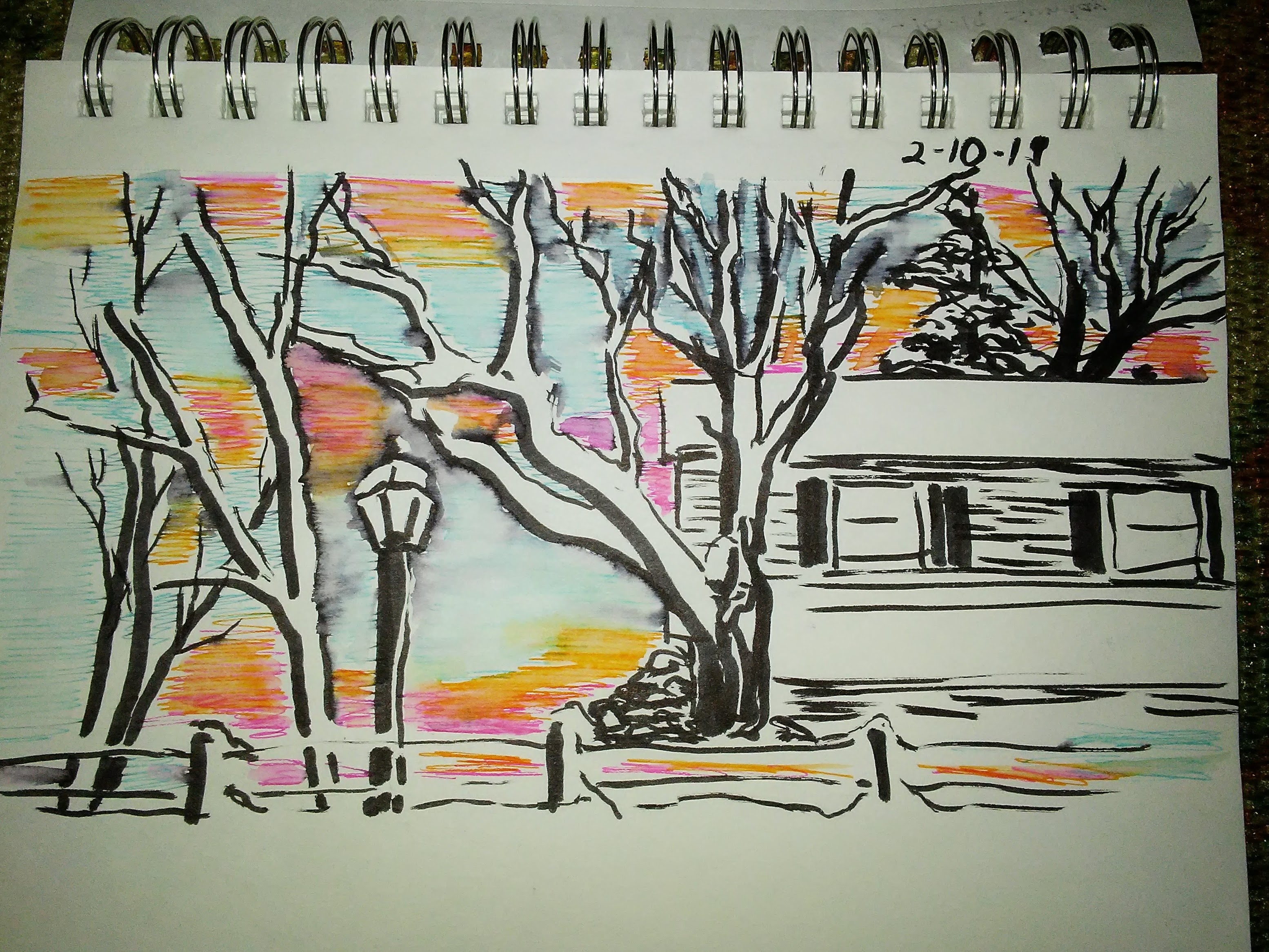 drawing in spiral notebook of trees and a house and a lightpost.