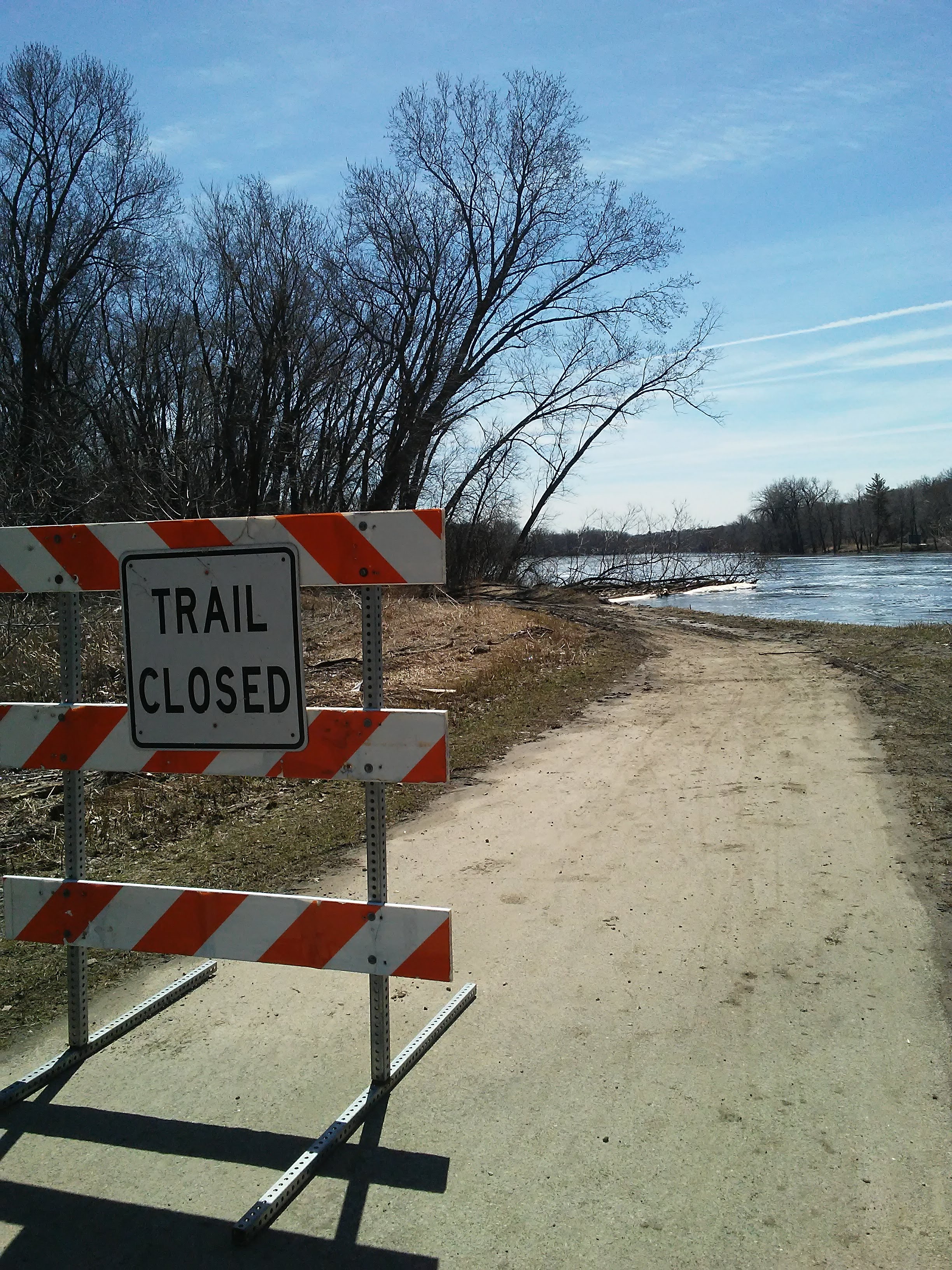 Trail closed sign and trail going to water