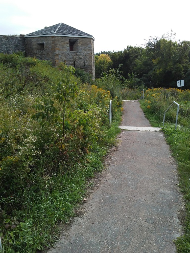 old stone fort and overgrown wild plants and a path