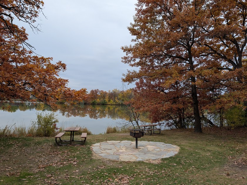 picnic table by a lake in autumn