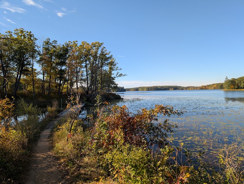 photo of lake and trail with footbridge